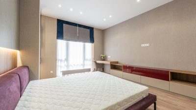 Bare white mattress on a bed frame in a modern bedroom