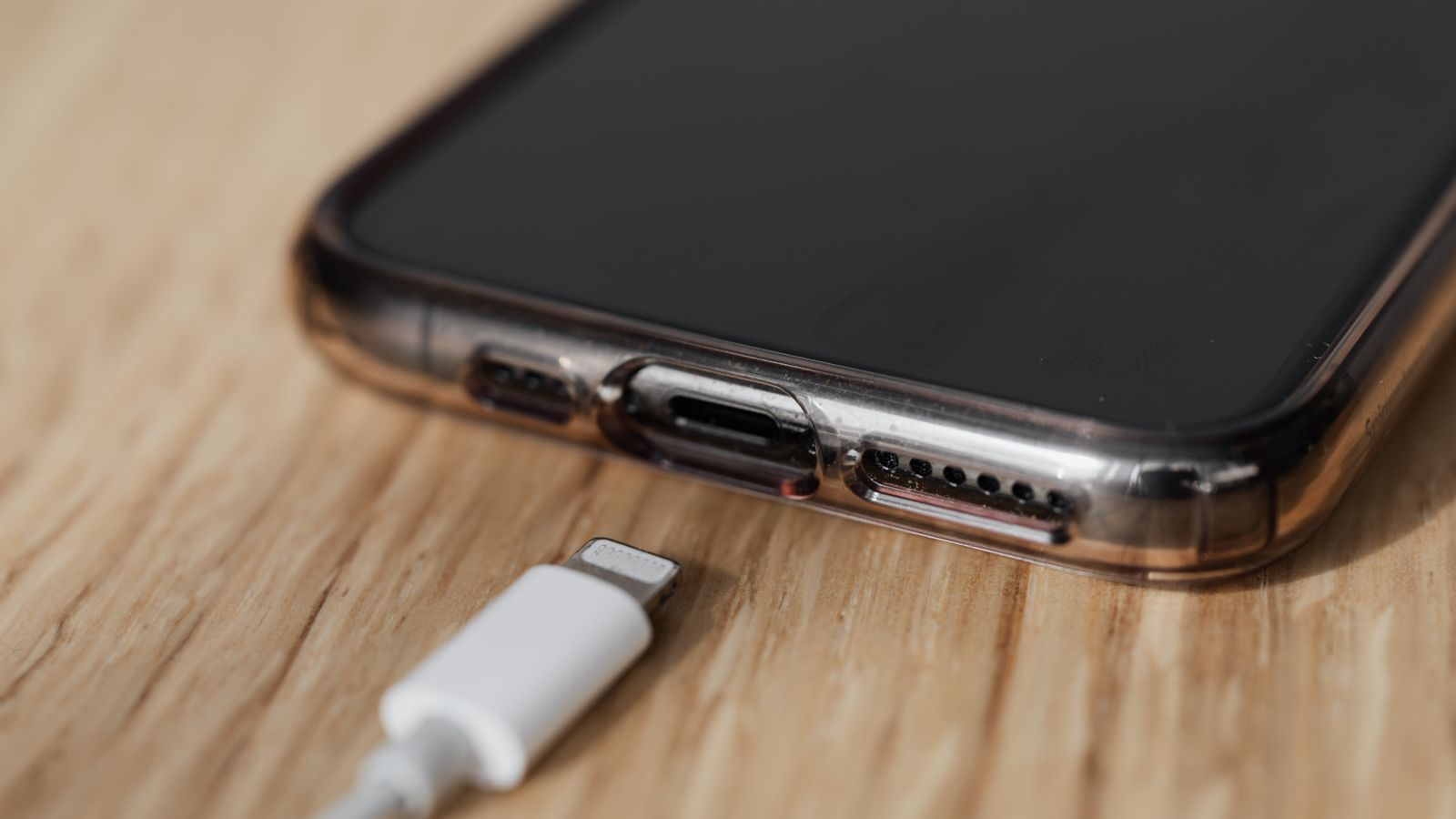 Close-up of a charging cable beside a smartphone's charging port