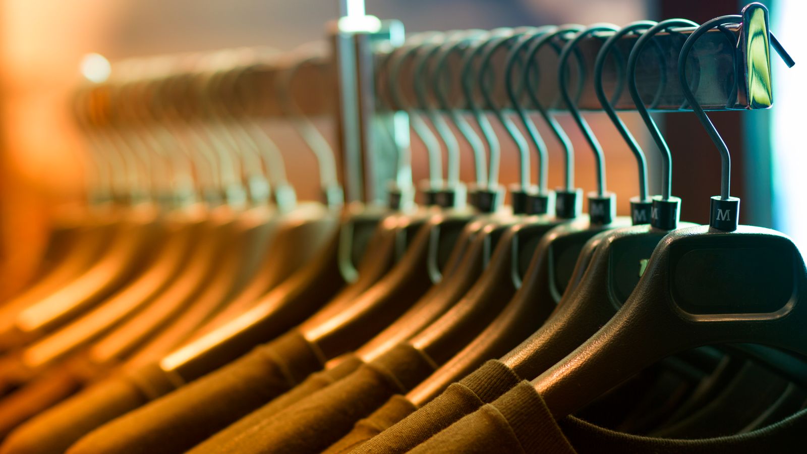 Row of clothes on wooden hangers on a rack