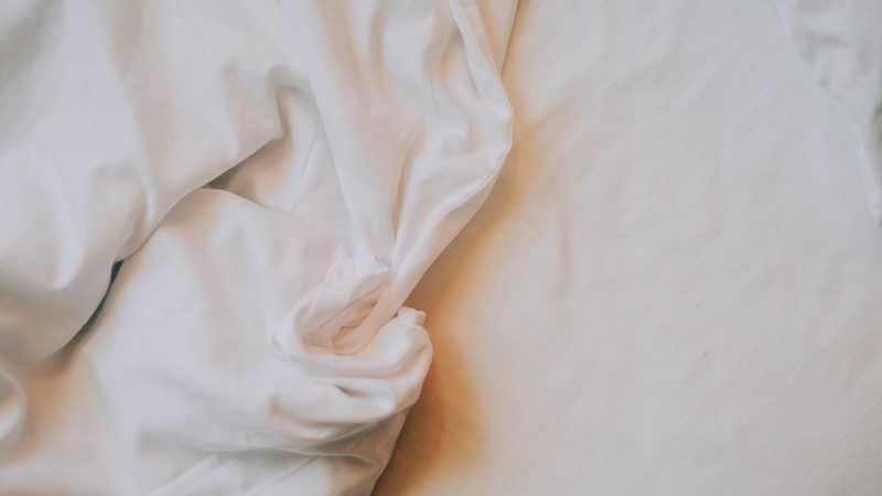 Crumpled white bed sheets in soft light
