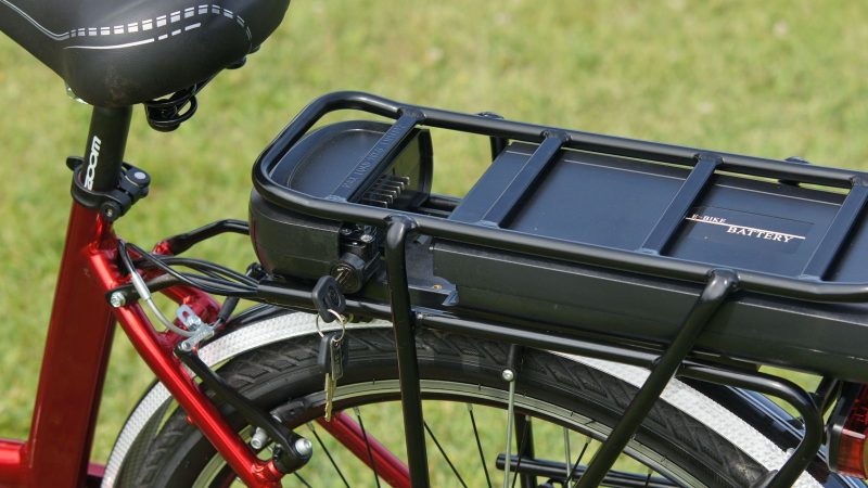 Battery pack mounted on the rear rack of a red electric bicycle