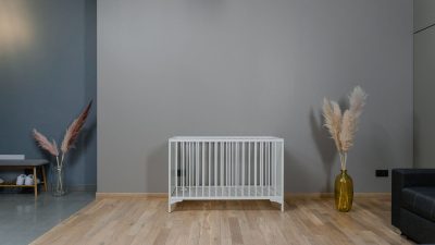Empty white crib in a plain room