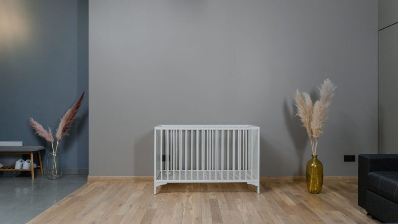 Empty white crib in a plain room