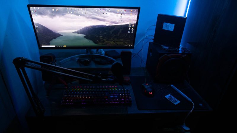 Gaming desk with a monitor and backlit keyboard in blue light