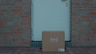 Cardboard package marked fragile left outside a front door