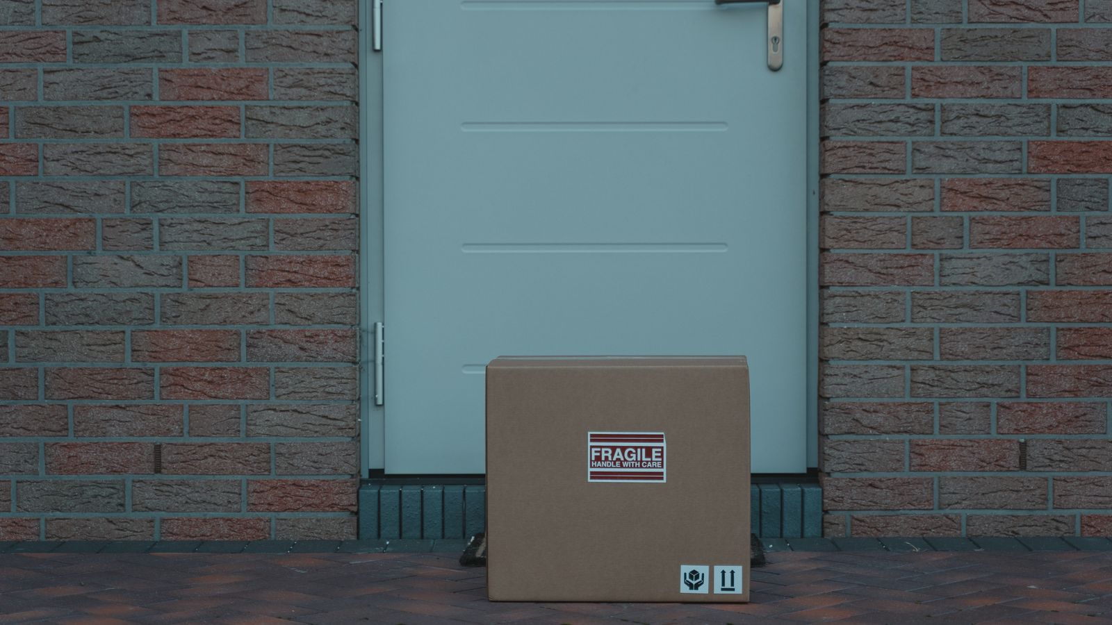 Cardboard package marked fragile left outside a front door