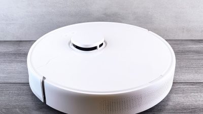 White robot vacuum cleaner on a wooden floor