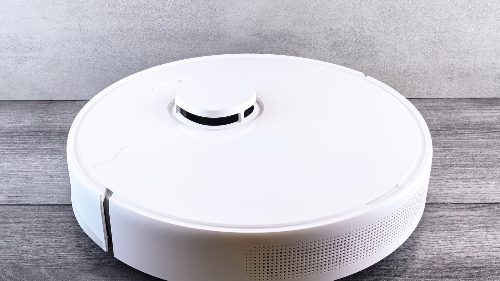White robot vacuum cleaner on a wooden floor