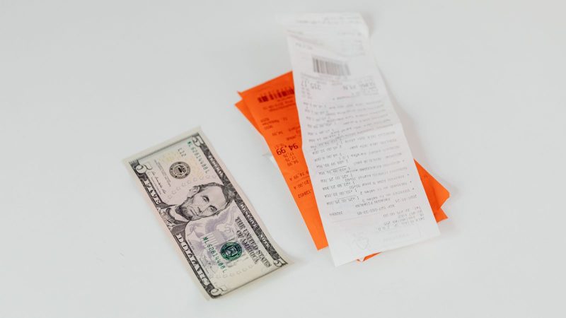Store receipts and a banknote on a white surface