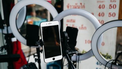 Smartphone on a tripod surrounded by ring lights