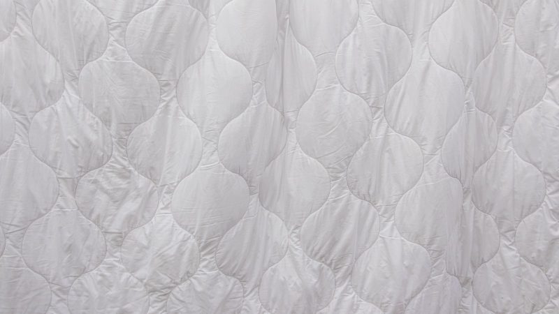 Close-up of white quilted bedding fabric