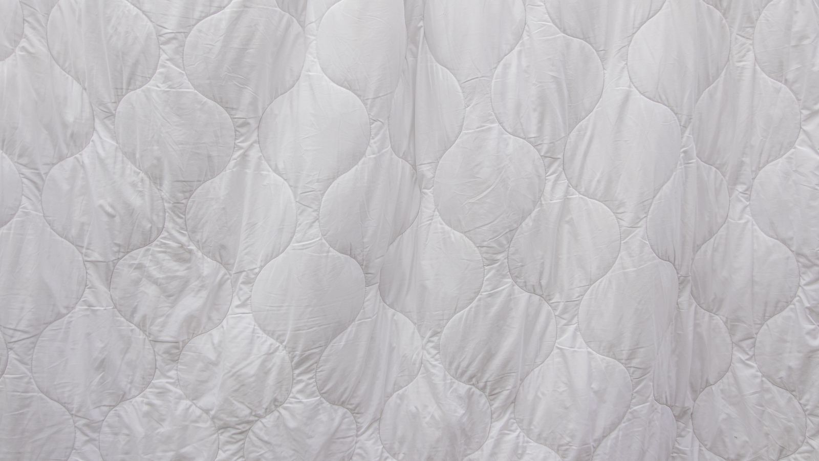 Close-up of white quilted bedding fabric