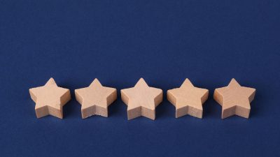 Five wooden stars in a row on a blue background
