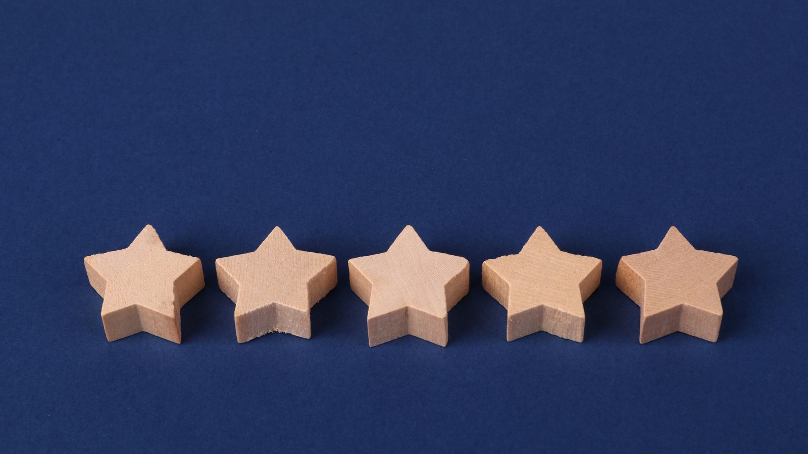Five wooden stars in a row on a blue background